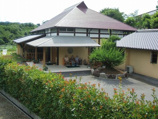古民家風の建物の周りには緑も多く、玄関先には数名の入居者が座っている。