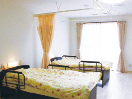 ２台ベッドが置かれた部屋にはレースカーテンとカーテンが付いている大きな窓がある。部屋の中央をカーテンで仕切ることができる。