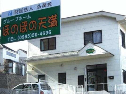 一軒家の外観によく似た雰囲気の建物。手すりが付いているエントランスの様子
