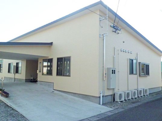 車いす用のスロープと雨除けのひさしがついた施設の外観写真