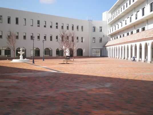 Vの字型の建物は白を基調とした3階建てで、各フロアにはバルコニーが付いている。