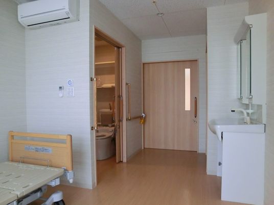 介護用ベッドとトイレ、洗面所が設置されている個室