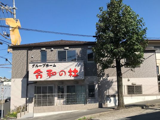 ２階建ての建物の外観。令和の杜と書かれた看板が見えている写真