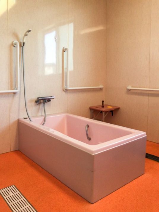 手すりが付いたシンプルな内装になっている浴室