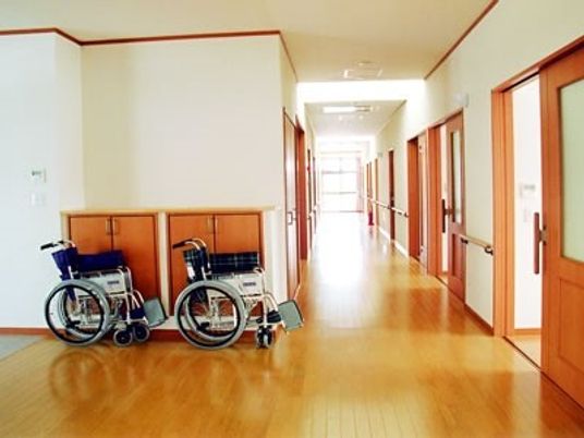 車いすが２台置いてある施設内の廊下の様子。手すりがついている安全な施設内