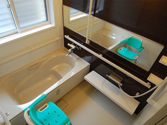 一人用の浴槽が設置された個浴室にはシャワーやシャワーチェアもあり、手すりが付いている。