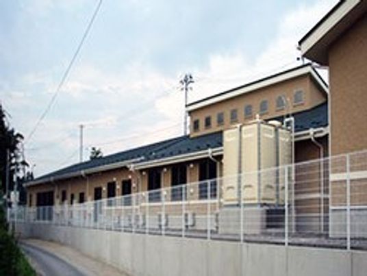 ブラウン系の建物にはグレーの屋根が付き、窓もたくさんついている。緑も多い。