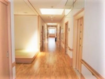 フローリングの床の廊下と両側の扉の写真。長く続く手すりも写っている様子