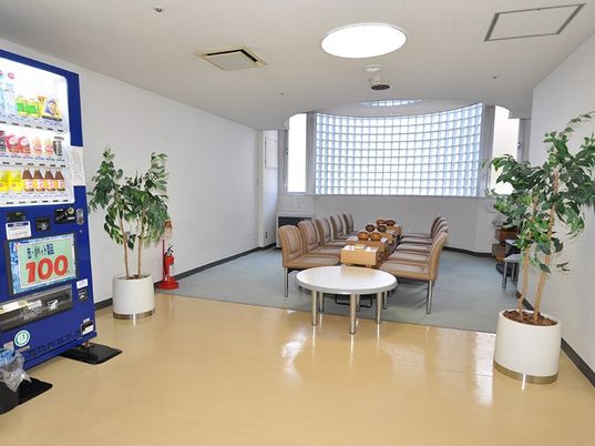 手前に自動販売機がある施設内のリラックススペースの様子。椅子が並んでいるスペース