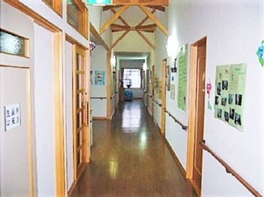 両サイドに手すりがあるまっすぐな廊下には居室のドアが並び、突き当りには大きな窓がある。