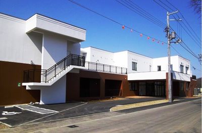 駐車場付きの白い建物の外観