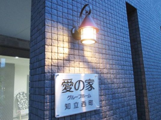 看板と街灯のある外観