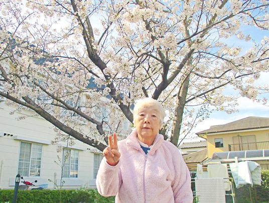 桜と高齢者のポーズ
