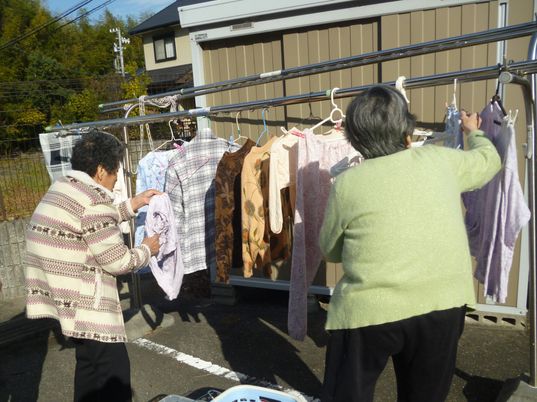 屋外で洗濯物を干す人々
