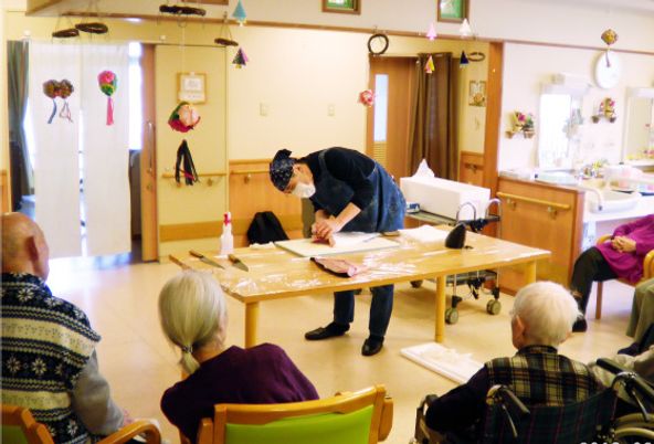 集まる人々と作業台