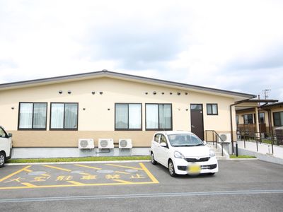 白い建物と駐車場の外観
