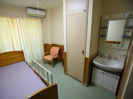 居室の洗面台とベッド