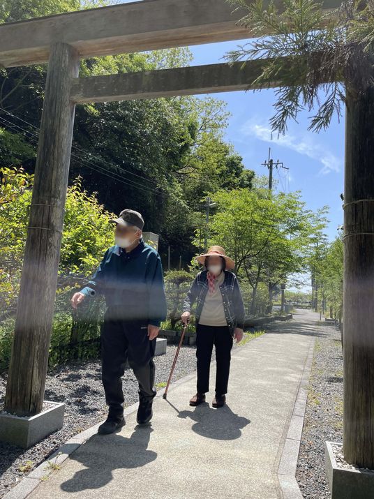 青空のもと散歩する二人の高齢者