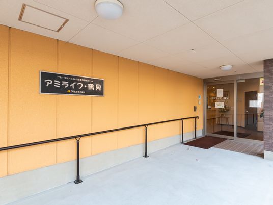 黄色の壁とエントランス看板