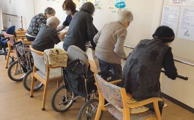 高齢者が並ぶ訓練室