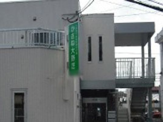 緑の看板が目立つ建物外観