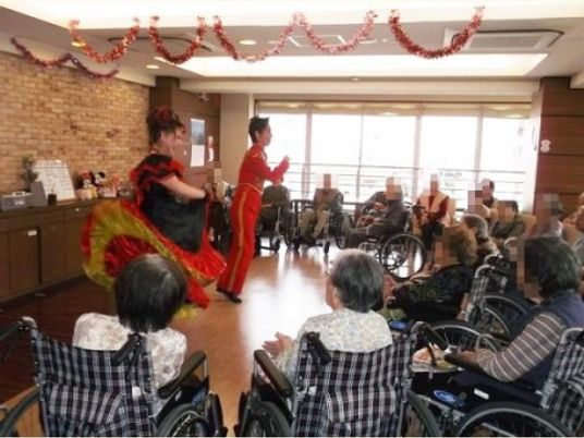 車椅子の傍で踊る人々