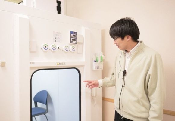 詳しい説明をする職員と機械装置