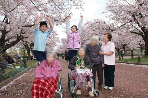 桜並木を背景にした施設利用者との交流