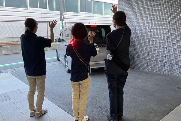 車に手を振る人々の様子