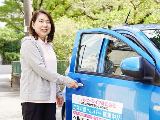 笑顔で車のドアに触れる女性