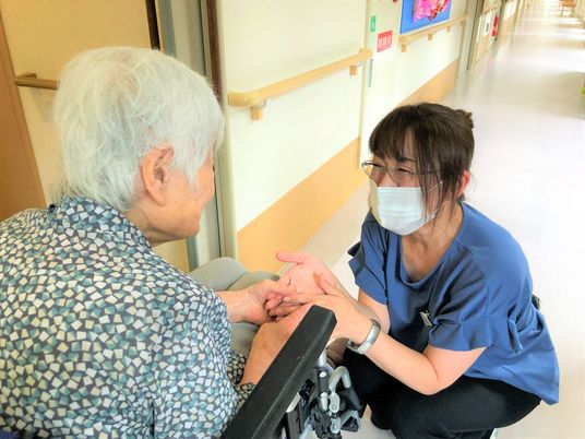 スタッフと利用者の手を取り合う場面