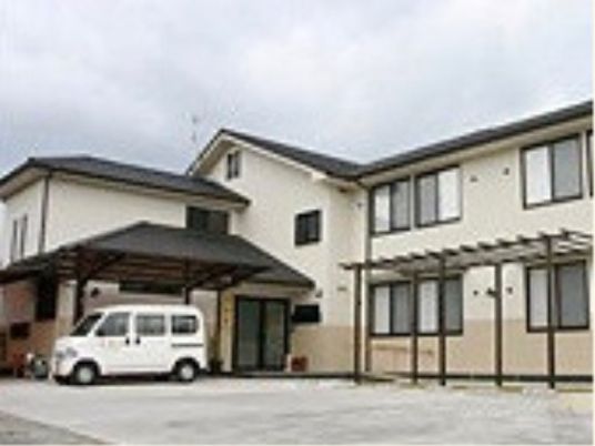 白い車が停まった建物外観