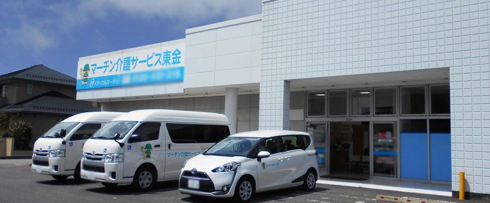 送迎用の車と建物の外観