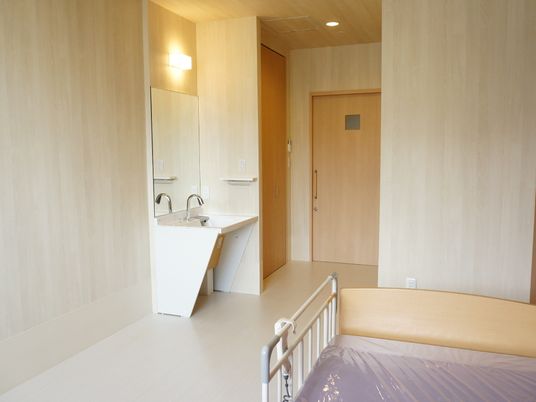 居室の洗面台とベッド