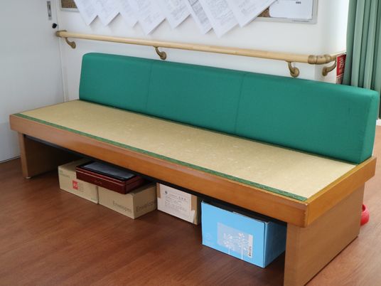 緑のソファベンチと掲示物