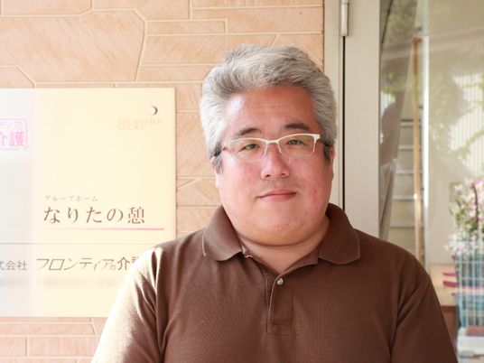 笑顔のスタッフと看板