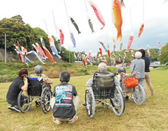 利用者が外で鯉のぼりを見る