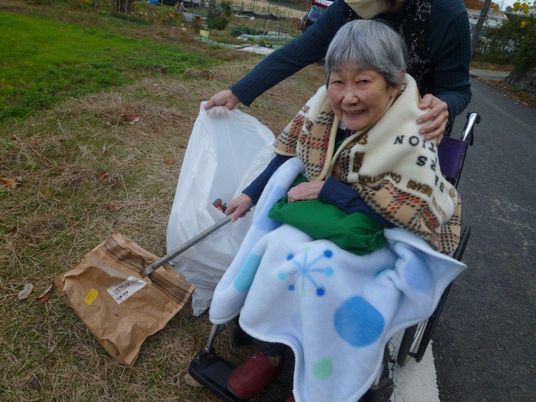 車椅子の高齢者と介助者