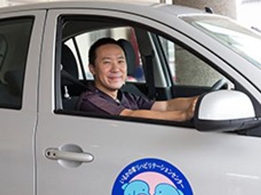 笑顔の職員が運転する車