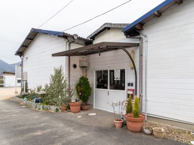 白壁の建物入口と草花