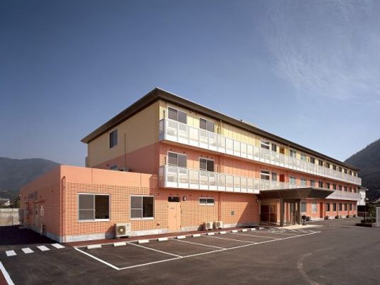 クリーム色の建物と駐車場