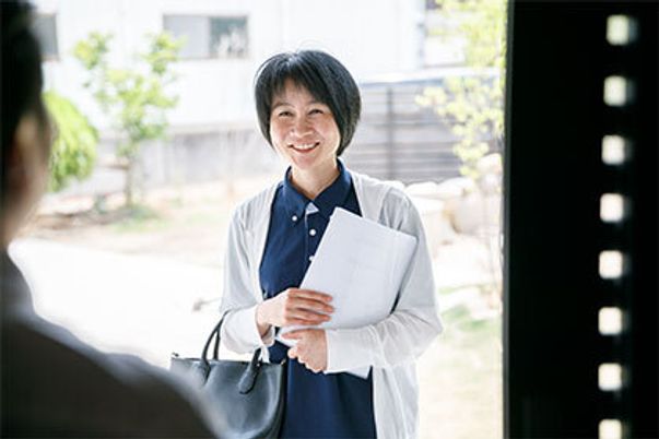 玄関で微笑む女性