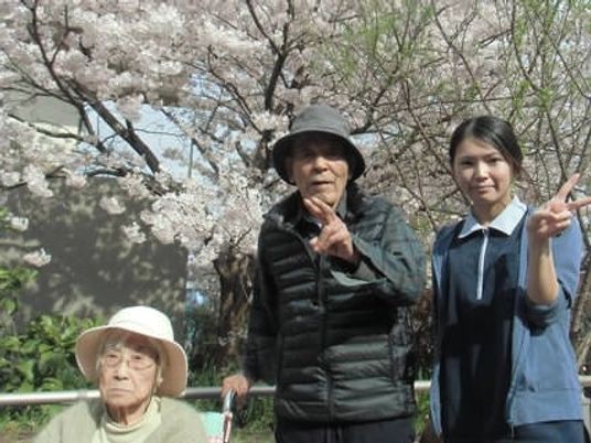 桜の木と笑顔のスタッフ