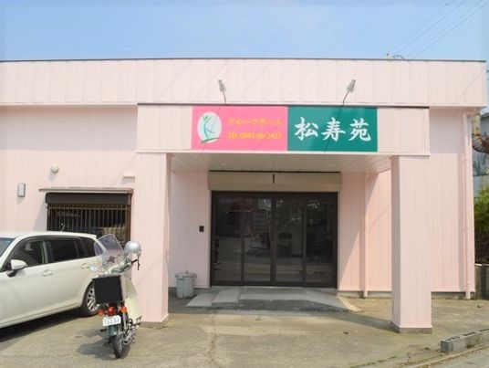 ピンクの外壁の建物エントランス