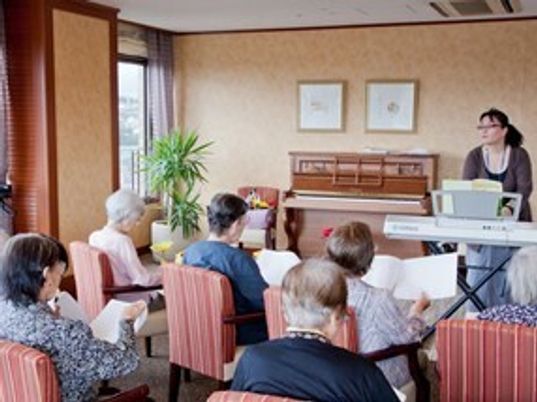 椅子に座る人々とスタッフ