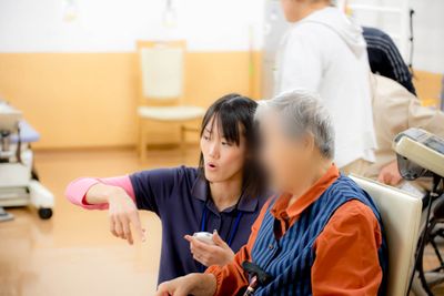 笑顔の介護士さんと利用者さん、多目的室
