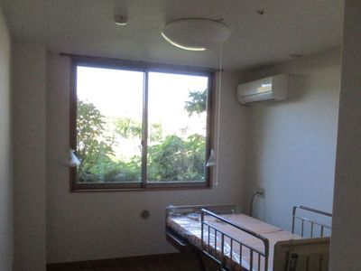 明るい個室の窓とベッド