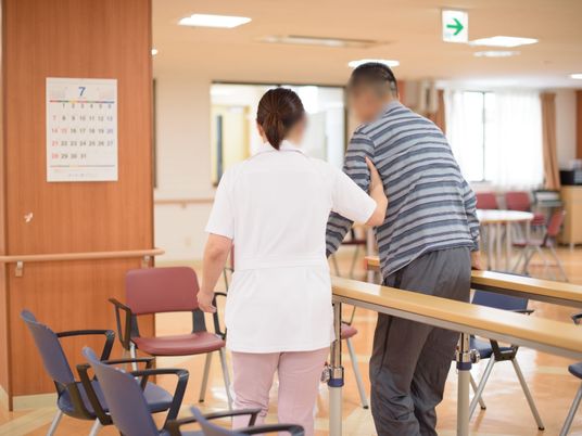 歩行補助を受ける利用者