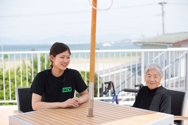 テラスで会話するスタッフと利用者