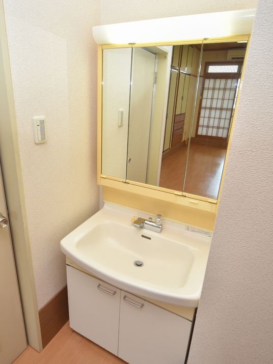 清潔な洗面台と背後の廊下